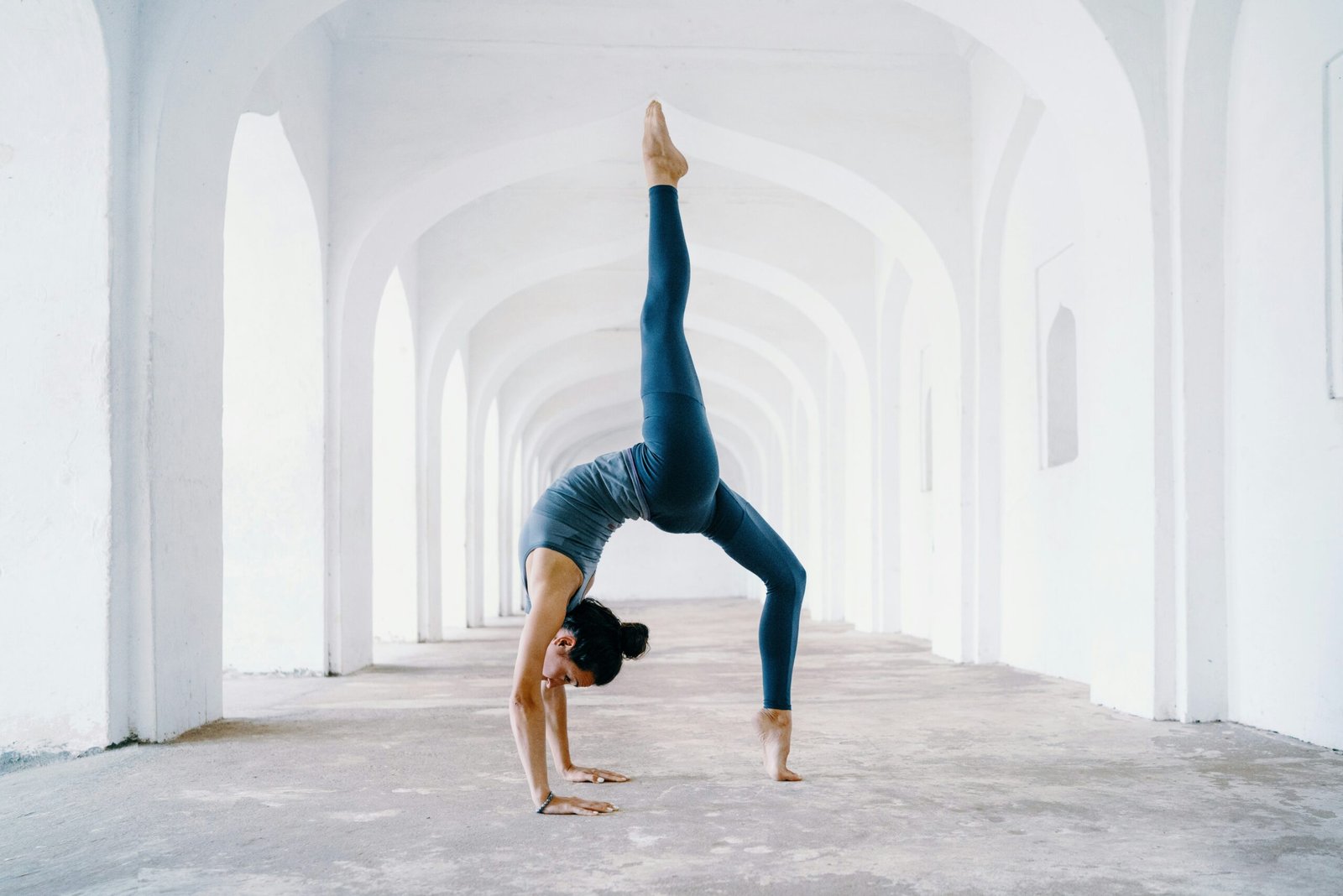 woman in blue leggings and black tank top doing yoga